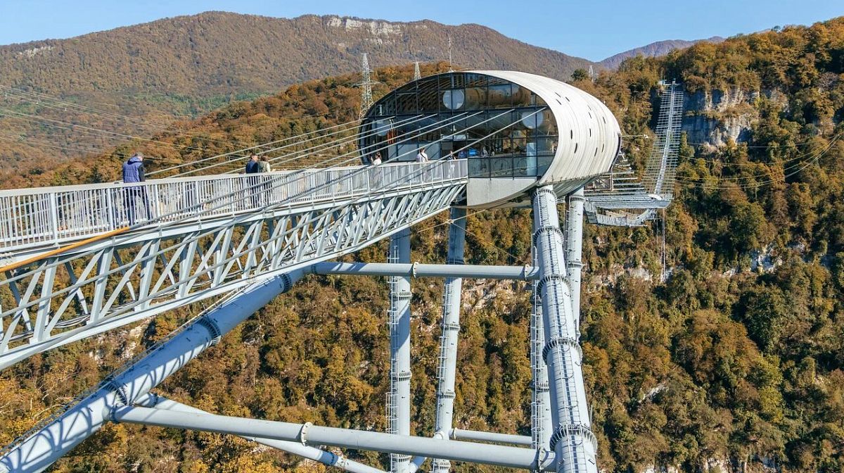 Подвесной мост Skybridge и станция с капсулой над осенним лесом Ахштырского ущелья