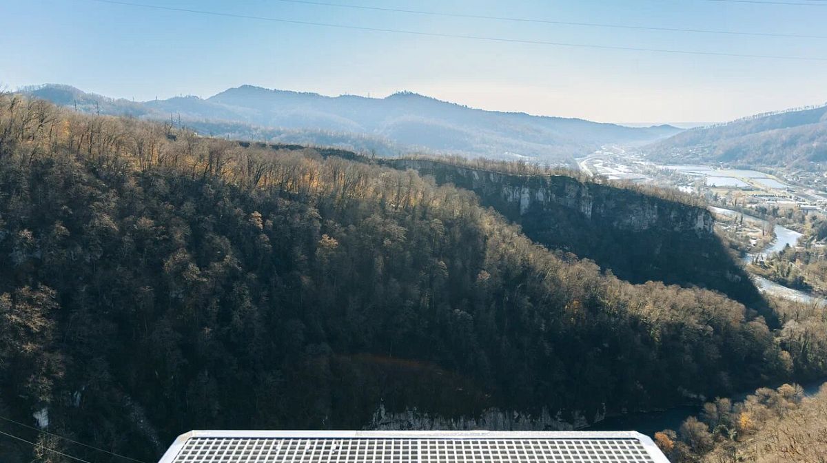 Вид на ущелье и лесистые склоны с решётчатой платформы капсулы Bungy 207 в Скайпарке