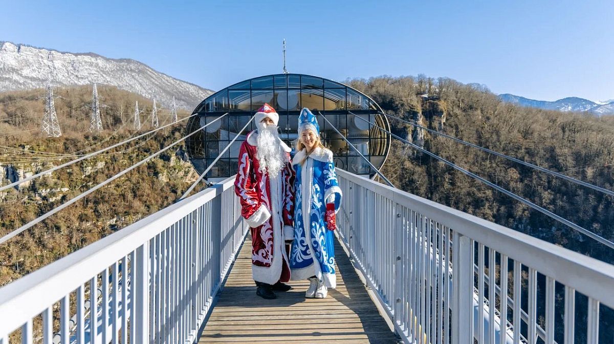 Дед Мороз и Снегурочка на мосту Skybridge в Скайпарке на фоне заснеженных гор